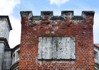 Redbrick tower in the old wall masonry. Aged bricks, white seam