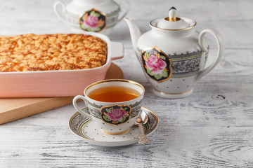 Delicious homemade lemon tart pie with green tea on rustic white