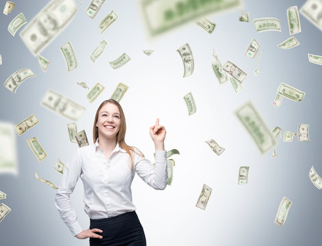 Woman with finger in the air under money rain