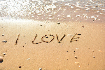 the inscription on the sand near the sea on a sunny day