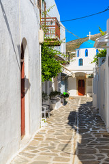 Street in Parikia town with church in distance on Paros island, Greece