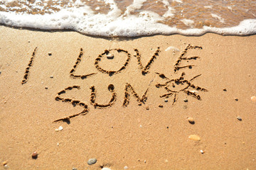 the inscription on the sand near the sea on a sunny day