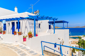 Typical Greek whitewashed house on street in Naoussa town on Paros island, Greece © pkazmierczak