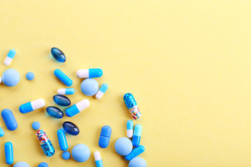 Heap of pills on yellow background