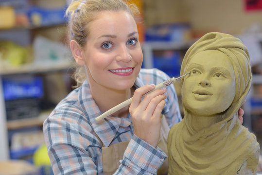 artisan woman finishing sculpture in a studio