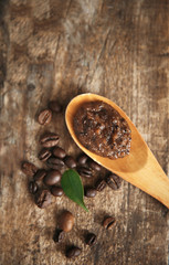 Coffee body scrub in spoon on wooden background