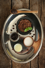 Coffee body scrub in jar and ingredients on silver tray