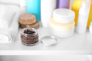 Coffee body scrub and cosmetics on white table
