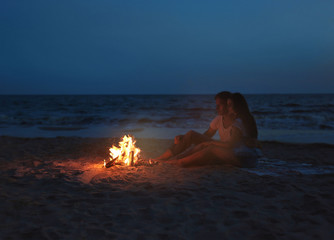 Lovely couple near fireplace on beach