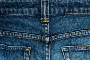 Blue jeans back pocket with a close-up. Fabric texture high resolution