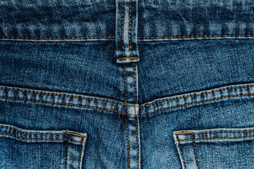 Fototapeta premium Blue jeans back pocket with a close-up. Fabric texture high resolution