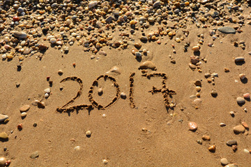 the inscription on the sand near the sea on a sunny day