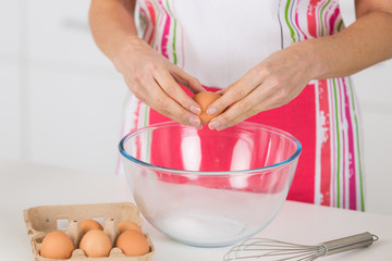 hands breaking an egg in bowl on table