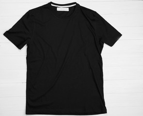 Blank black t-shirt on light wooden background