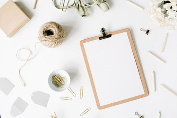 Flat lay, top view office table desk. feminine desk workspace mock up with clipboard, twine, pencils, floral bouquet, craft diary and clips on white background.