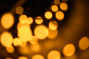 Vintage blur bokeh defocused golden colorized lights on dark room background