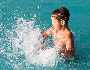 boy swims with a splash in the water park