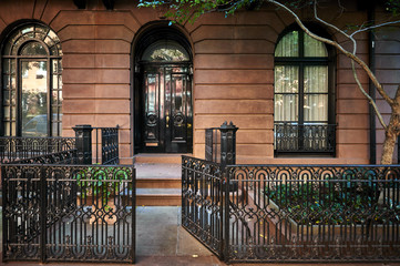 the front steps and door of an ornate brownstone building