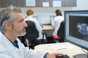 Senior medic studying image on screen