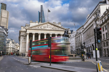 London, England - The Royal Exchange building with moving red double decker bus
