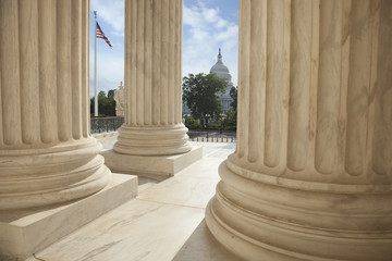 Columns of the Supreme Court with an American flag and the US Ca