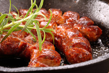 Sausage frying in a pan