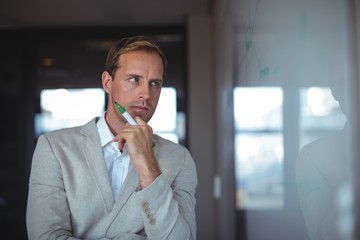 Thoughtful businessman looking at whiteboard