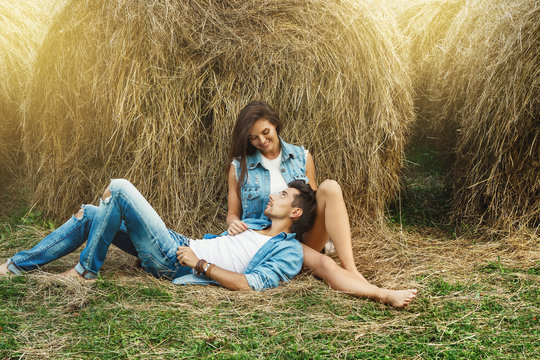 Young lovely couple is relaxing among the haystacks