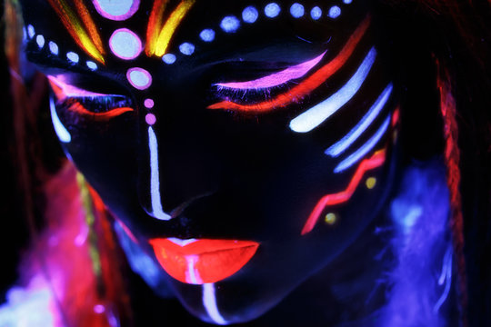 Woman with a neon makeup in ultraviolet light