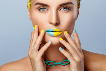 Beautiful woman with yellow hair and colorful nails and lips