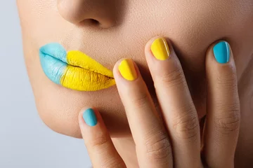 Weibliche Lippen mit zwei verschiedenen Lippenstiften und bunten Nägeln © blackday