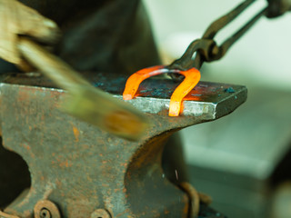 Hammering glowing steel - to strike while the iron is hot.