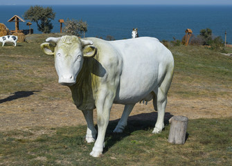 white toy cow with a bell