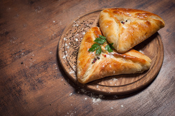 traditional georgian baked food kubdari on wooden table;