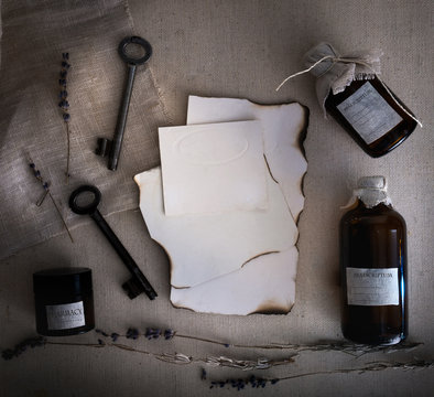 Sheets burnt paper, cans and bottles, old keys, dry lavender. top view