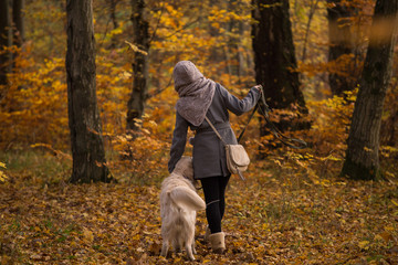 Fototapeta premium girl with a dog on a leash is on the road a golden retriever