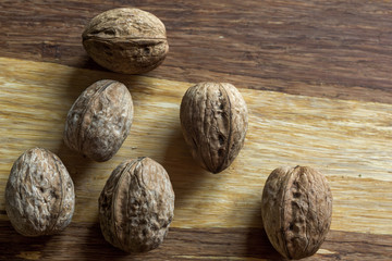 Composition with walnuts over brown wooden background