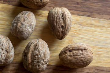 Composition with walnuts over brown wooden background