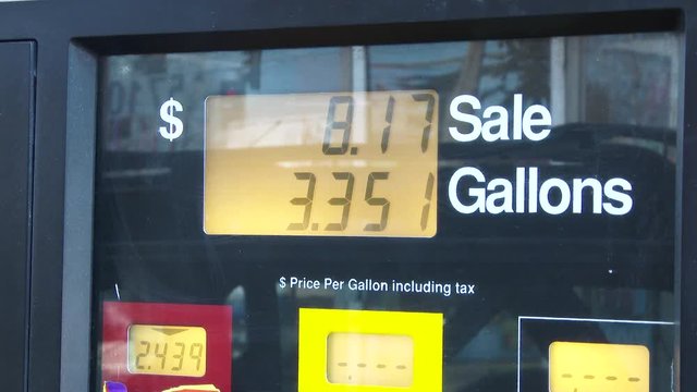 Time lapse video at gas station pump filling up, close up on price per gallon as fuel pumps.