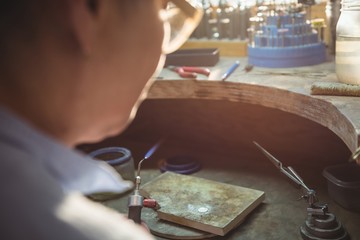Craftswoman using blow torch in workshop