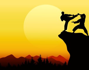 silhouettes of two people fighter on the cliff at sunset