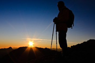 Mountaineer silhouette at the sunset on the top of Gartnerkofel above Nassfeld pass, Austria