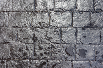 Close up texture of wet black brick wall background.