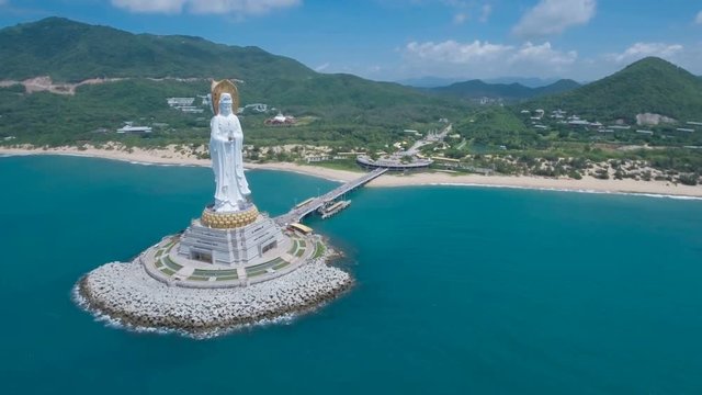 Flying towards a tall white Buddha statue on the tropical island Hainan, China