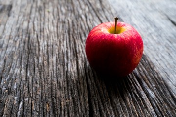 Apple with shadow on wooden background.