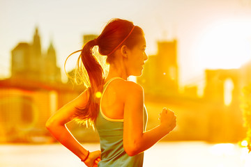 Running woman Asian runner in New York city sunset. Runner jogging in sunny bright light. Female...
