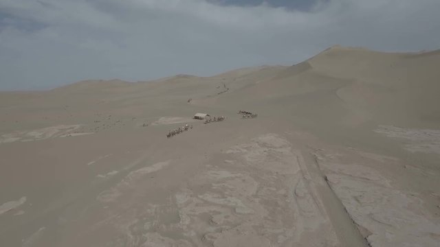 Aerial view of Chinese tourists riding camels through the deserts near Dunhuang
