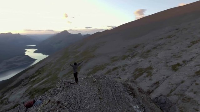 Young woman celebrates reaching peak of mountain hike