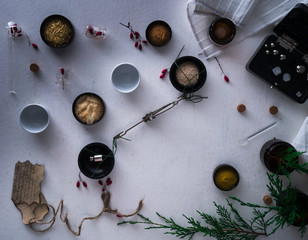 jars of powders, barberry berries, leaves burnt paper, scales, a set  weights on the table. top view