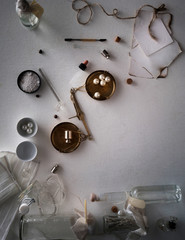 jars of powders, leaves burnt paper, scales on the table. top view